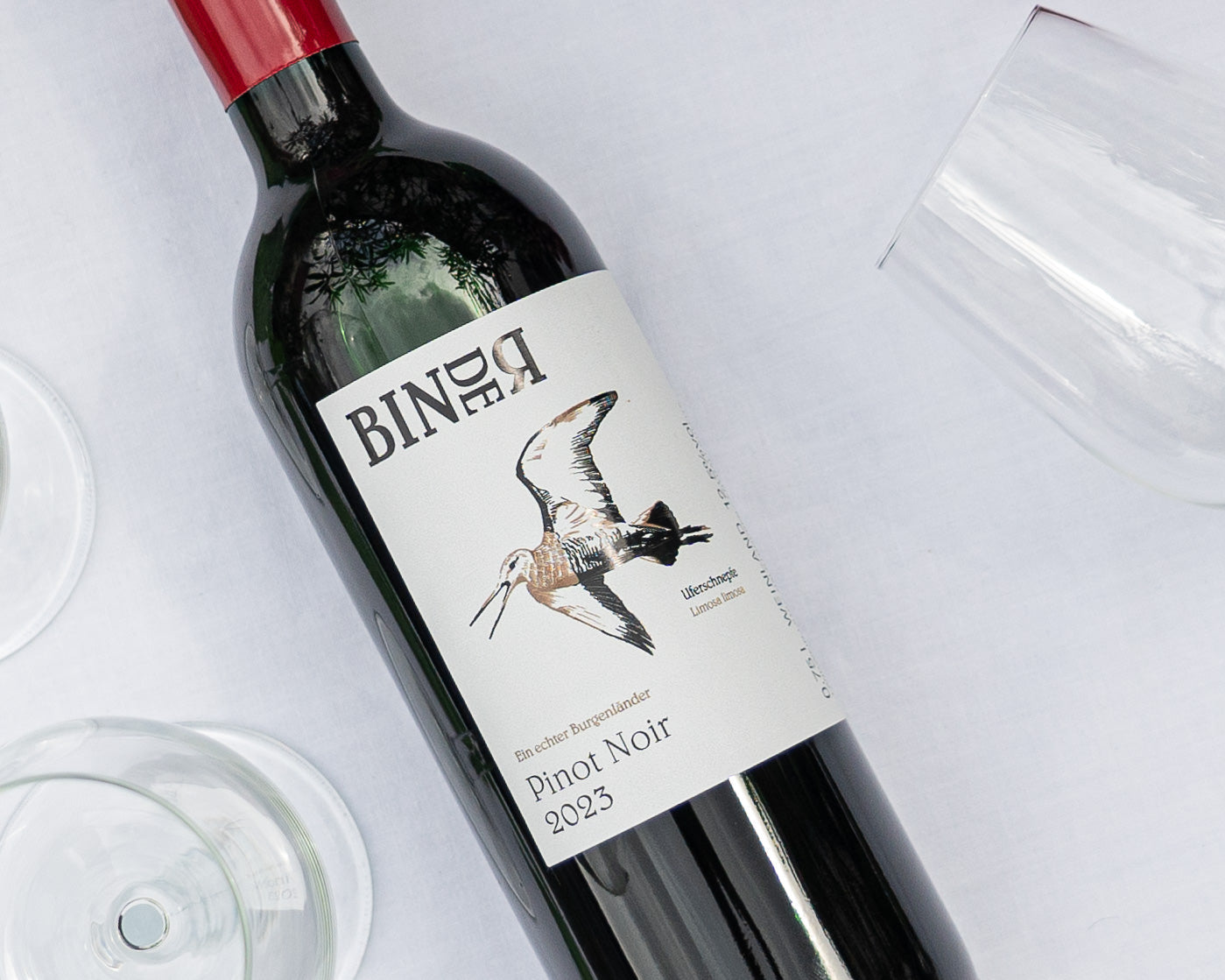 Pinot Noir vom Weingut Binder aus Mörbisch am See, Neusiedlersee, Burgenland, Österreich. Auf der Etikette der Weinflasche eine Uferschnepfe.