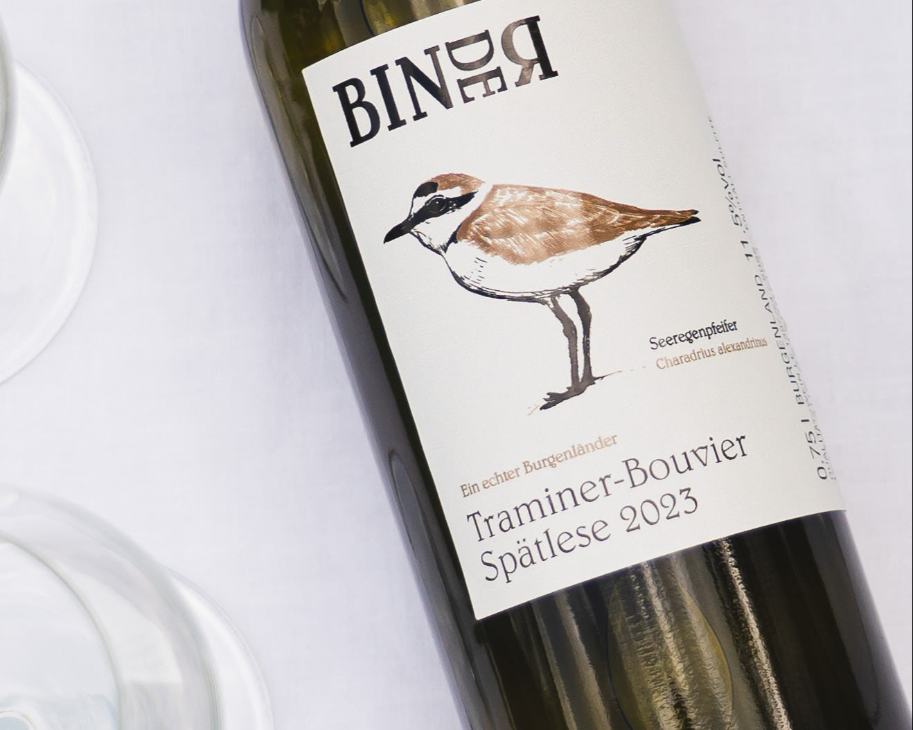 Traminer Bouvier Spätlese vom Weingut Binder aus Mörbisch am See, Neusiedlersee, Burgenland, Österreich. Auf der Etikette der Weinflasche ein Seeregenpfeifer.