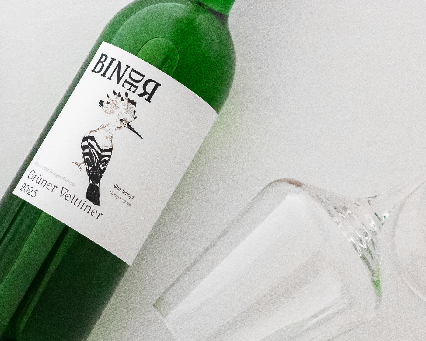 Grüner Veltliner vom Weingut Binder aus Mörbisch am See, Neusiedlersee, Burgenland, Österreich. Trockener Weißwein. Auf der Etikette der Weinflasche ein Wiedehopf.
